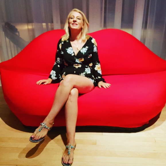 tracy martin with red lips chair
